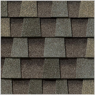 Close-up of overlapping gray textured asphalt roof shingles in a staggered pattern.